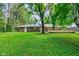 Brick ranch home featuring large yard and wooden deck perfect for outdoor gatherings and enjoying nature at 3339 Devereaux Dr, Indianapolis, IN 46228