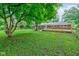 This backyard features a well-maintained lawn, mature trees, and a newly constructed wooden deck at 3339 Devereaux Dr, Indianapolis, IN 46228