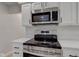 Modern kitchen featuring stainless steel stove and microwave with white shaker cabinets at 3339 Devereaux Dr, Indianapolis, IN 46228