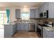 Updated kitchen features stainless appliances, granite countertops, mosaic backsplash and wood-look flooring at 3623 Carroll Farms Dr, Indianapolis, IN 46235