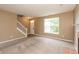 Bright living room features neutral carpeting, a staircase, and plenty of natural light at 3623 Carroll Farms Dr, Indianapolis, IN 46235