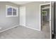 This bedroom features light grey carpet, neutral grey walls, a window and a closet at 3627 N Brentwood Ave, Indianapolis, IN 46235