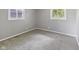 An empty bedroom features light grey carpet, gray walls, and two double hung windows at 3627 N Brentwood Ave, Indianapolis, IN 46235