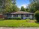 Charming single-story home featuring gray siding, dark shutters, and a lush green lawn at 3627 N Brentwood Ave, Indianapolis, IN 46235