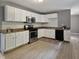Kitchen featuring white cabinets, stainless steel appliances, and light wood floors at 3627 N Brentwood Ave, Indianapolis, IN 46235