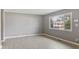 Living room featuring gray walls, light wood floors, and view to the front yard at 3627 N Brentwood Ave, Indianapolis, IN 46235