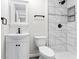 Well-lit bathroom featuring stylish marble tile shower, vanity with mirror, and modern fixtures at 3716 W 16Th St, Indianapolis, IN 46222