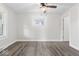 Cozy bedroom with gray floors, a ceiling fan, and a view of the neighborhood at 3716 W 16Th St, Indianapolis, IN 46222