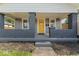 Home featuring a bright yellow front door, dark gray brick porch, and lush landscaping at 3716 W 16Th St, Indianapolis, IN 46222