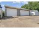 Two-car garage with gray siding and white doors, alongside a driveway and side yard at 3716 W 16Th St, Indianapolis, IN 46222