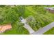 Aerial view of a house with mature trees, an expansive gravel driveway, a detached garage, and a green lawn at 425 Patterson Rd, Columbus, IN 47203