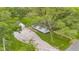 Aerial view of a home with mature trees, an expansive gravel driveway, and a detached garage at 425 Patterson Rd, Columbus, IN 47203