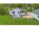 An elevated view showcasing the front deck, tidy lawn, and convenient detached garage at 425 Patterson Rd, Columbus, IN 47203