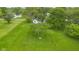 Aerial view of a green lawn with mature trees, utility access, and a white house with blue trim in the background at 425 Patterson Rd, Columbus, IN 47203
