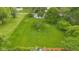 Aerial view of a green lawn with mature trees, utility access, and a white house with blue trim in the background at 425 Patterson Rd, Columbus, IN 47203