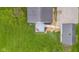 Aerial view of a house with a grey roof, a large lawn, a detached garage, and a grey deck with red chairs at 425 Patterson Rd, Columbus, IN 47203