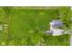 Aerial view of a property with a green lawn, mature trees, a house, and a detached garage with a gravel driveway at 425 Patterson Rd, Columbus, IN 47203