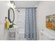 Bathroom featuring a sink, toilet, mirror, and tub with patterned shower curtain at 425 Patterson Rd, Columbus, IN 47203