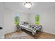 Bedroom with bright natural light, wood-look floors, and stylish black and white striped bedding at 425 Patterson Rd, Columbus, IN 47203