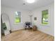 Bright bedroom with wood floor, stylish chair, standing mirror and two windows at 425 Patterson Rd, Columbus, IN 47203