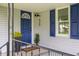 Inviting front porch featuring a bright blue door, stylish planters, and elegant black railings at 425 Patterson Rd, Columbus, IN 47203
