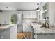 Bright kitchen features white cabinets, stainless steel appliances, granite counters, and a view to the outside at 425 Patterson Rd, Columbus, IN 47203