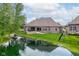 Picturesque backyard featuring a green lawn, a pond, and a well-maintained exterior of the home at 4359 Prairie Falcon Dr, Zionsville, IN 46077