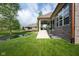 Beautiful backyard featuring a lush lawn, a pond, and a covered patio with stairs leading down from the house at 4359 Prairie Falcon Dr, Zionsville, IN 46077
