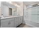 Bathroom featuring double sinks with granite counters, a large mirror, and a glass-enclosed shower-tub combination at 4359 Prairie Falcon Dr, Zionsville, IN 46077
