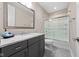 Modern bathroom featuring dark gray vanity with granite countertops, a large mirror, and a shower-tub combination at 4359 Prairie Falcon Dr, Zionsville, IN 46077