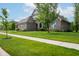 Beautiful single-story home with gray brick exterior, landscaped yard, and well-maintained lawn at 4359 Prairie Falcon Dr, Zionsville, IN 46077