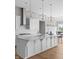 Bright kitchen features white cabinets, large island, stainless steel appliances, and stylish pendant lighting at 4359 Prairie Falcon Dr, Zionsville, IN 46077