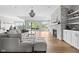 Spacious living room featuring a stone fireplace, hardwood floors, and expansive windows with views of the lake at 4359 Prairie Falcon Dr, Zionsville, IN 46077