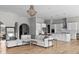 Open living room with hardwood floors, modern lighting, seamlessly connects to the kitchen with white cabinetry at 4359 Prairie Falcon Dr, Zionsville, IN 46077