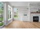 Bright living room with fireplace, built-ins, hardwood flooring and large windows that illuminate the room at 4359 Prairie Falcon Dr, Zionsville, IN 46077