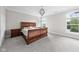 Serene main bedroom with wood furniture, plush carpet, and large windows showcasing the backyard at 4359 Prairie Falcon Dr, Zionsville, IN 46077
