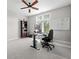 Bright office space featuring a ceiling fan, large window, modern desk setup, and ample natural light at 4359 Prairie Falcon Dr, Zionsville, IN 46077