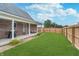 Green backyard with a covered patio, well-manicured lawn, and privacy fence at 4399 Summerhaven Dr, New Palestine, IN 46163