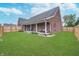 Spacious fenced backyard with lush green grass and covered outdoor seating area at 4399 Summerhaven Dr, New Palestine, IN 46163