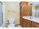 Well-lit bathroom featuring a wood cabinet, toilet, sink, and shower with glass door at 4399 Summerhaven Dr, New Palestine, IN 46163