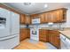 Functional kitchen with wooden cabinets, granite countertops, and white appliances including a modern refrigerator at 4399 Summerhaven Dr, New Palestine, IN 46163