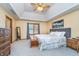 Comfortable main bedroom featuring a tray ceiling, carpet, ceiling fan, and natural light from the window at 4399 Summerhaven Dr, New Palestine, IN 46163
