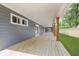 Expansive covered back porch with wood flooring and support columns, offering an inviting outdoor space at 4477 Devon Lake Rd, Indianapolis, IN 46226