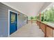 Inviting covered porch features a blue front door, wooden floor, brown posts and railings providing a warm welcome to the home at 4477 Devon Lake Rd, Indianapolis, IN 46226