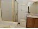 Well lit bathroom features a tub with glass doors, white tile and neutral vanity at 4528 Hunt Master Ct, Indianapolis, IN 46268
