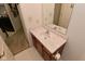 Small bathroom with a wooden vanity, white sink and toilet paper roll holder at 4528 Hunt Master Ct, Indianapolis, IN 46268