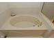 Close-up shot of a bathtub with gold fixtures and soap on the side at 4528 Hunt Master Ct, Indianapolis, IN 46268