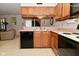 Traditional kitchen features wood cabinets, laminate countertops, and black appliances at 4528 Hunt Master Ct, Indianapolis, IN 46268