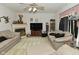Cozy living room features a ceiling fan, fireplace, and comfortable beige couches at 4528 Hunt Master Ct, Indianapolis, IN 46268
