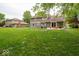 Spacious backyard with green grass, mature trees, a patio with a table and chairs, and a well-manicured lawn at 506 Deerberry Dr, Noblesville, IN 46062